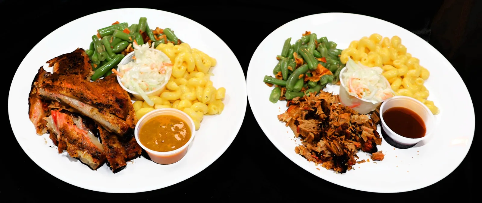 Two plates of ribs and pulled pork with mac and cheese, green beans, coleslaw, and sauce at The Venue Clermont